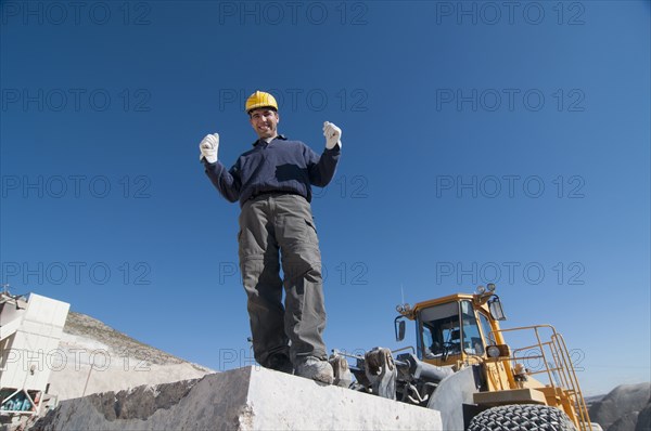 joyful worker on top of marble slab in quarry