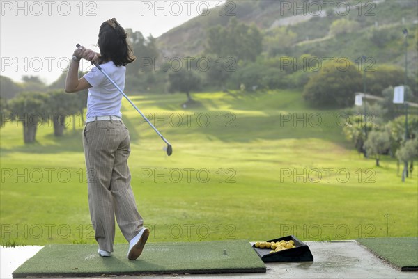 Female golfer on golf course rear view