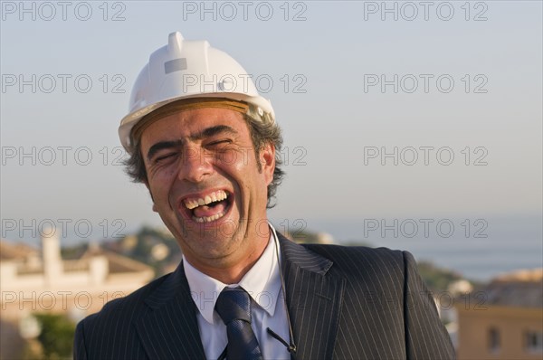 laughing businessman wearing hard hat