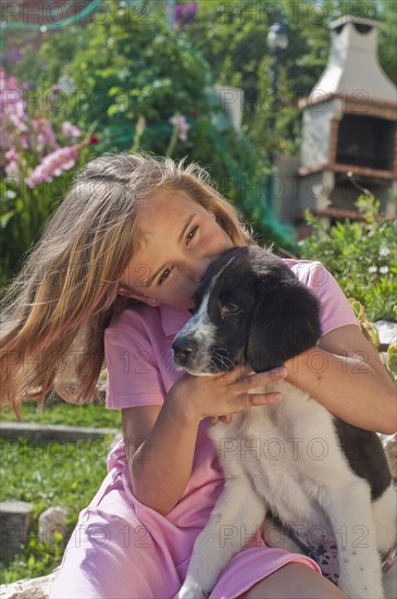 young girl with dog in garden