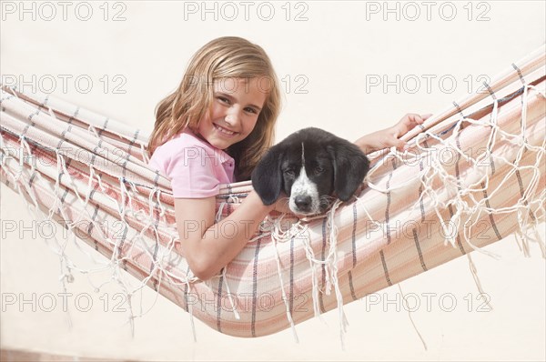 young girl with dog in hammock