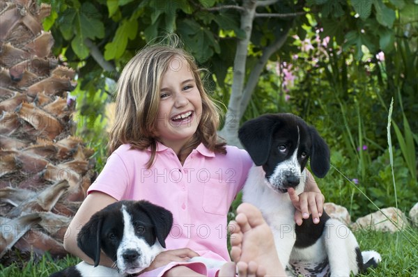young girl with dogs in garden