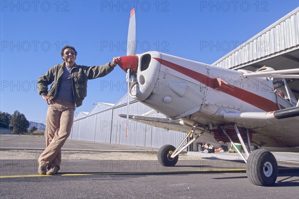 Smiling Man Standing Next to a Monoplane