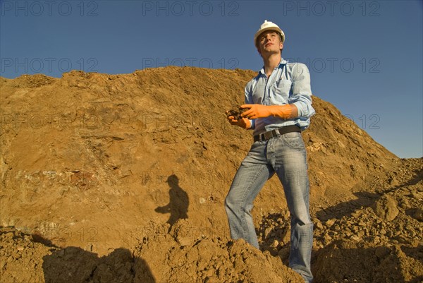 Young engineer checking soil samples on construction site