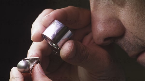 Jeweller exaning ring with loupe close-up