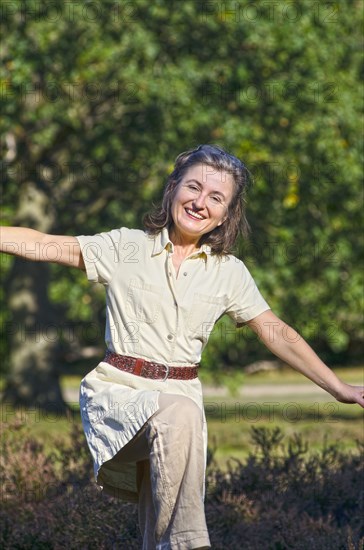 woman spreading arms in flying motion smiling