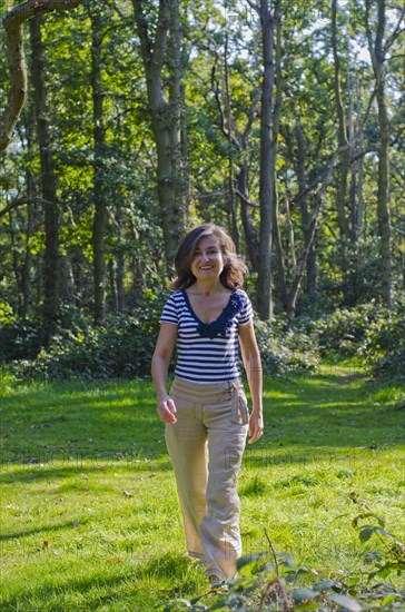 woman walking across clearing in forest