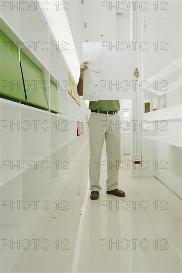 Male architect looking at plan in recently finished office building