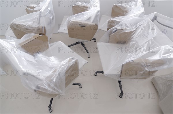 New office chairs covered in protective plastic sheets