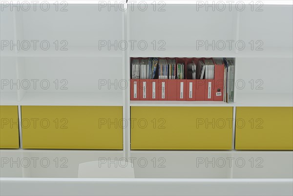 Magazines on coloured shelf in office building