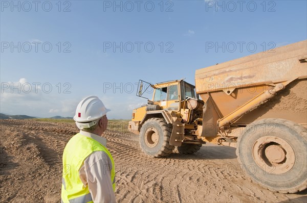 construction worker looking at earth moving truck