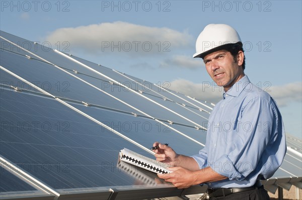 engineer with plans and solar panels