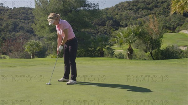 Caucasian woman putting on golf course
