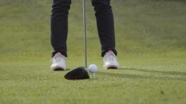 Caucasian woman teeing off on golf course