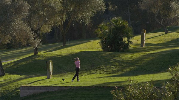 Caucasian woman teeing off on golf course