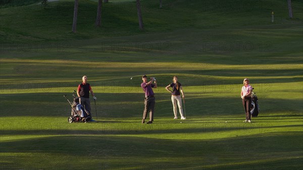 Caucasian friends playing golf on course