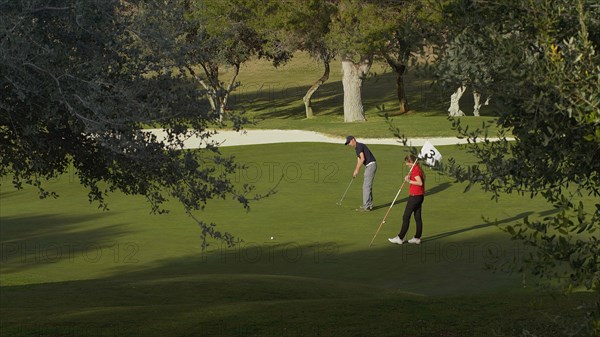 Caucasian couple putting on golf course