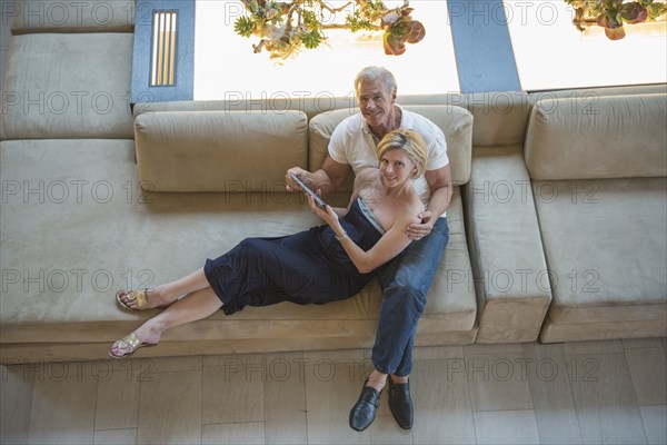 High angle view of Caucasian couple using digital tablet in hotel lobby