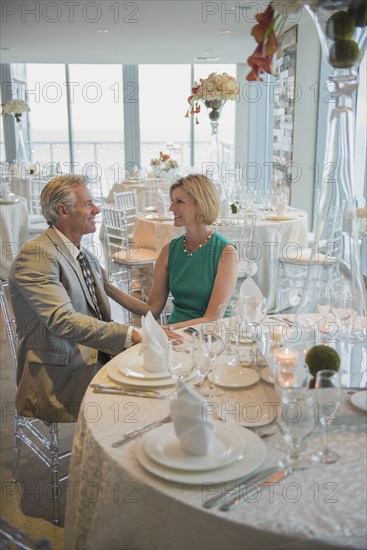 Caucasian couple talking in empty restaurant