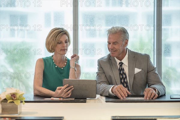 Caucasian business people using digital tablet in meeting