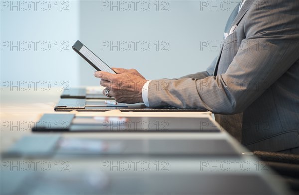 Caucasian businessman using digital tablet at conference table