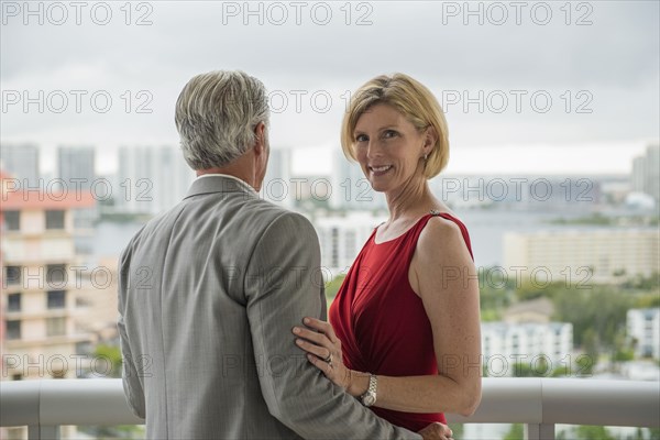 Caucasian couple hugging on balcony