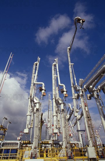 Low angle view of shipping cranes in industrial shipyard