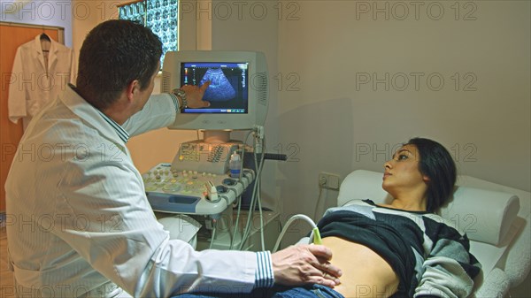 Doctor using ultrasound on pregnant woman