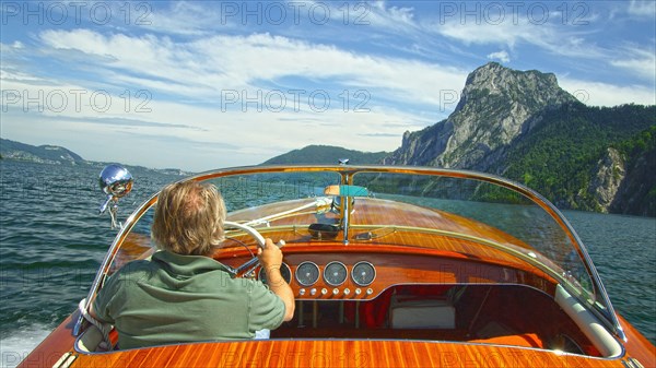 Caucasian man driving speedboat on remote lake