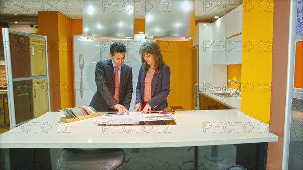 Hispanic salesman showing client samples in kitchen