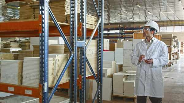 Hispanic worker checking inventory in factory