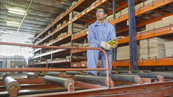 Hispanic worker checking inventory in factory