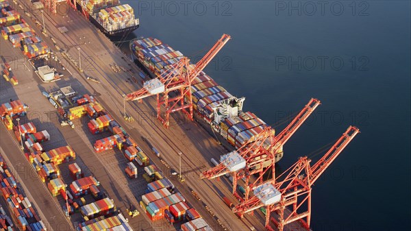 Aerial view of containers and cranes in industrial shipyard