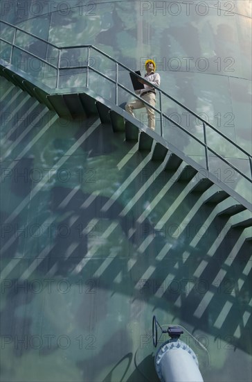 Hispanic worker standing on silo staircase