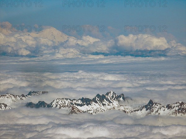 Snow covered mountaintops above clouds