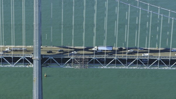 Aerial view of cars and trucks driving on bridge