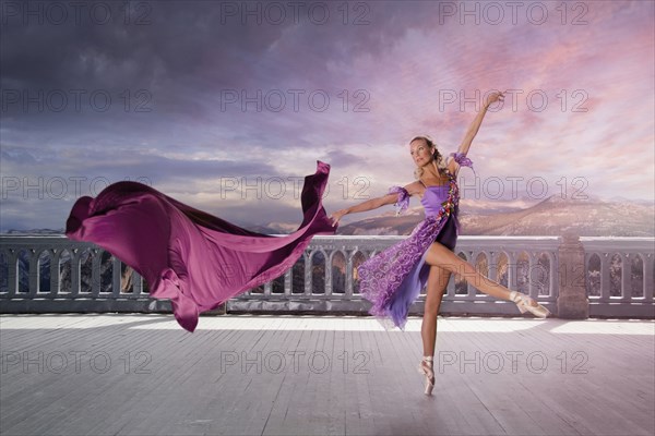 Caucasian woman ballet dancing on balcony