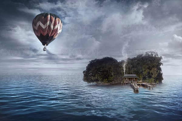 Hot air balloon floating over house on tropical island