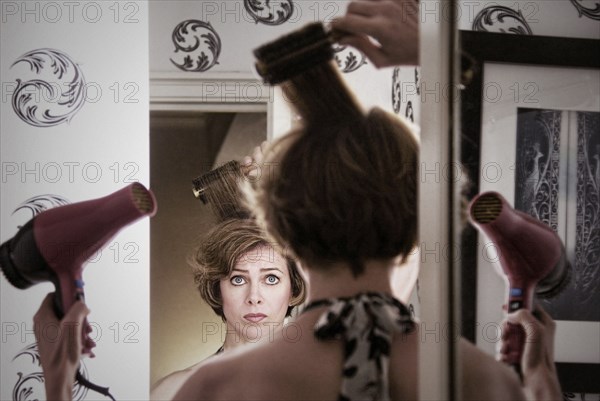 Overwhelmed Caucasian woman styling her hair