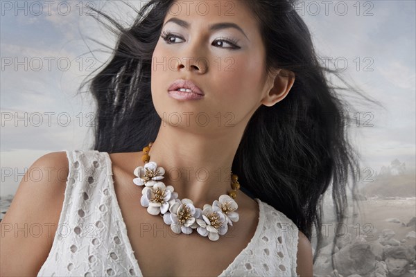 Close up of Asian woman standing on rocky coast