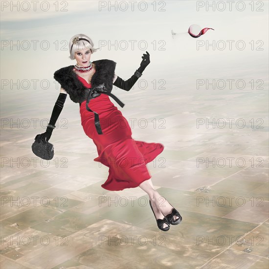 Woman in evening gown with glass of wine floating in sky