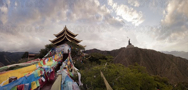 Panoramic view of prayer flags and traditional building on mountain