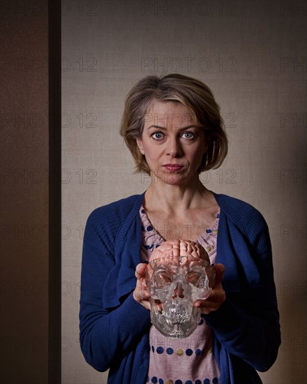 Caucasian woman holding model skull