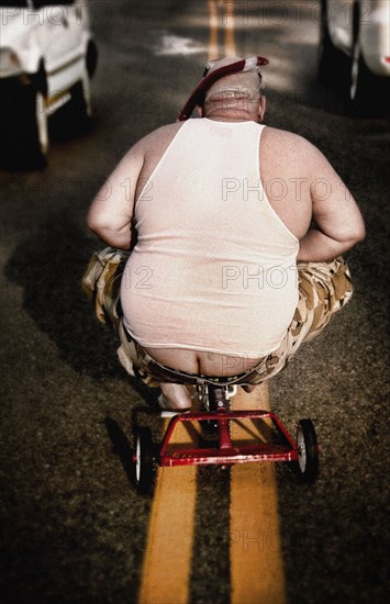 Man riding tricycle in street