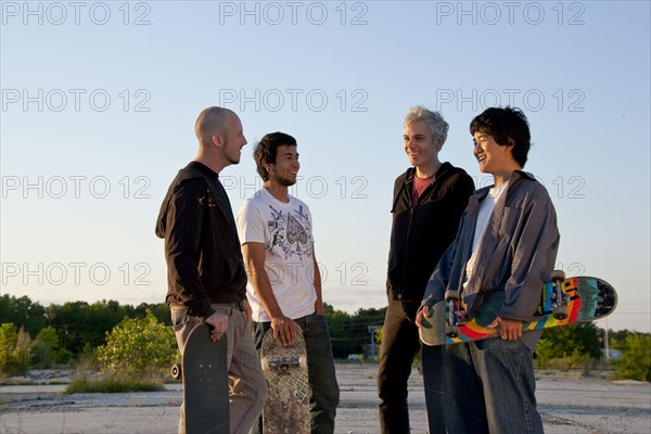 Men holding skateboards in parking lot