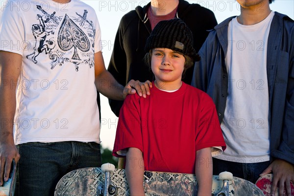 Men and boy posing with skateboard