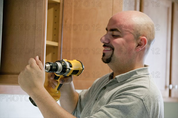 Contractor using power drill in house