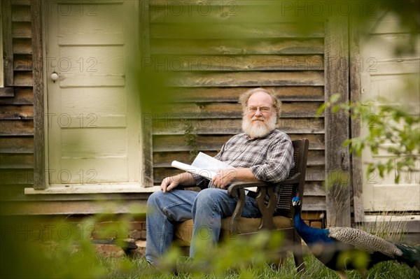 Caucasian man sitting in armchair outdoors