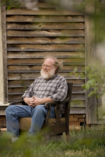 Caucasian man sitting in armchair outdoors