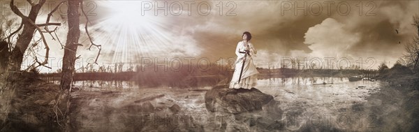 Caucasian woman standing on rock in remote lake